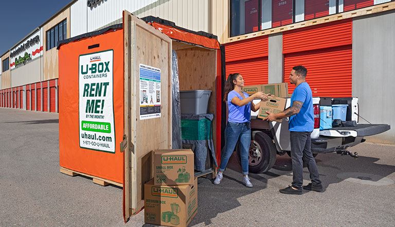 Couple loading a U-Box� container in front of a U-Haul Storage facility