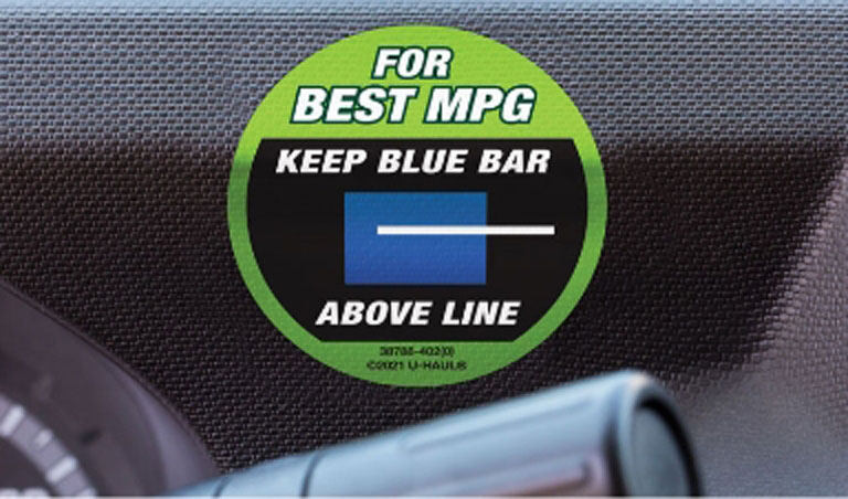 A fuel efficiency decal on the dashboard of a U-Haul truck