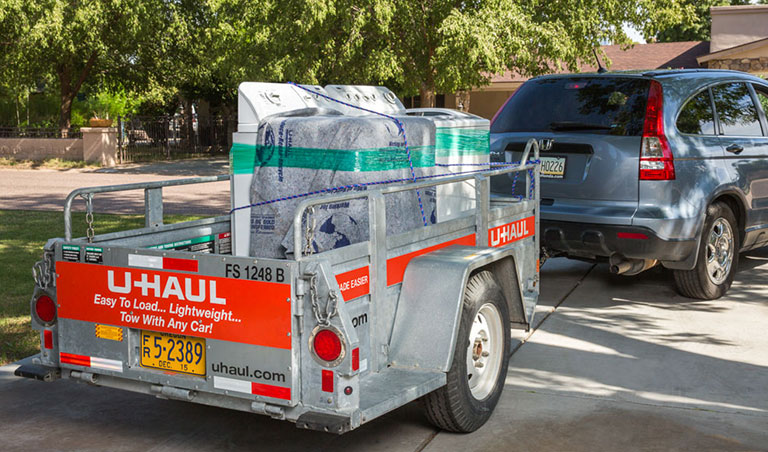 A fleet of U-Haul rental trucks in front of a U-Haul self-storage facility