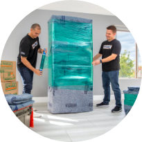 2 men wrapping furniture in protective wrapping
