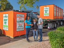 A couple and a moving professional reviewing U-Box containers on a truck