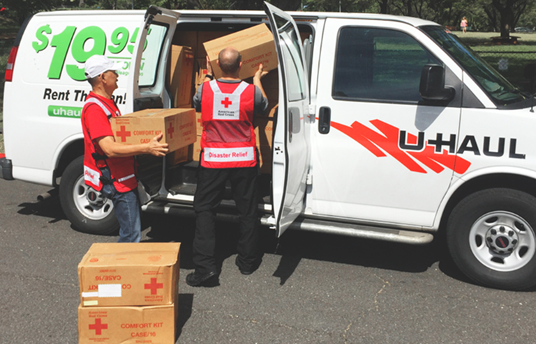U-Haul employee volunteers loading disaster relief supplies into a U-Haul cargo van