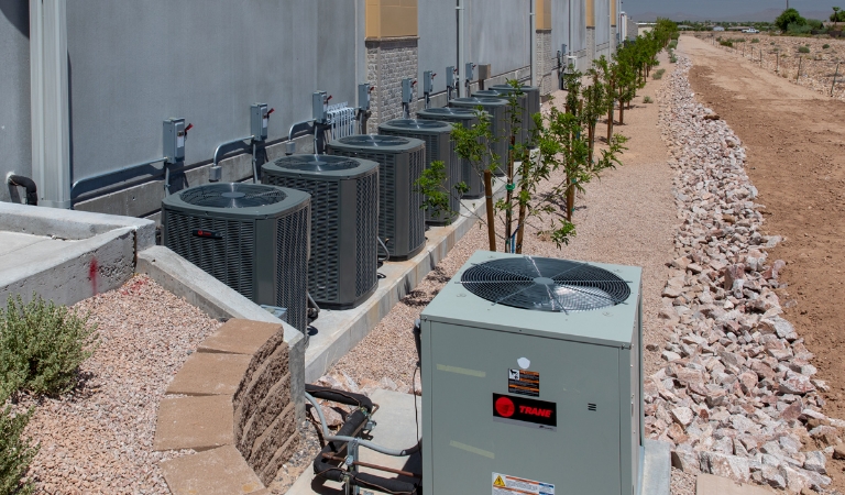 Air conditioning units on the ground next to a building