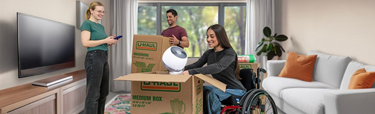 Woman in wheelchair packing U-Haul moving boxes with friends in a living room