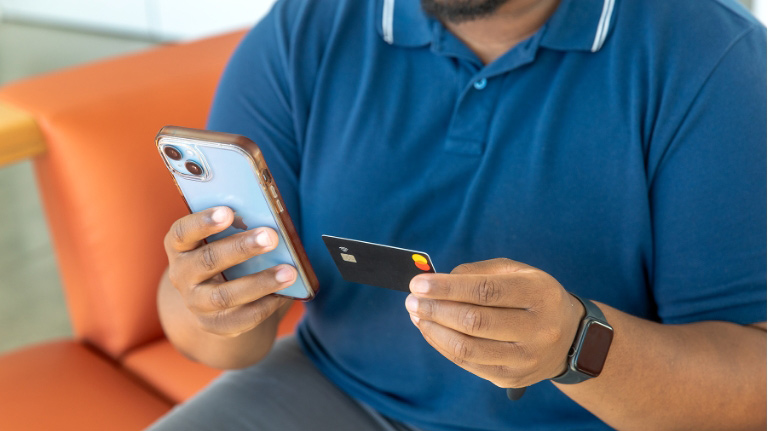 Man holding a phone and credit card