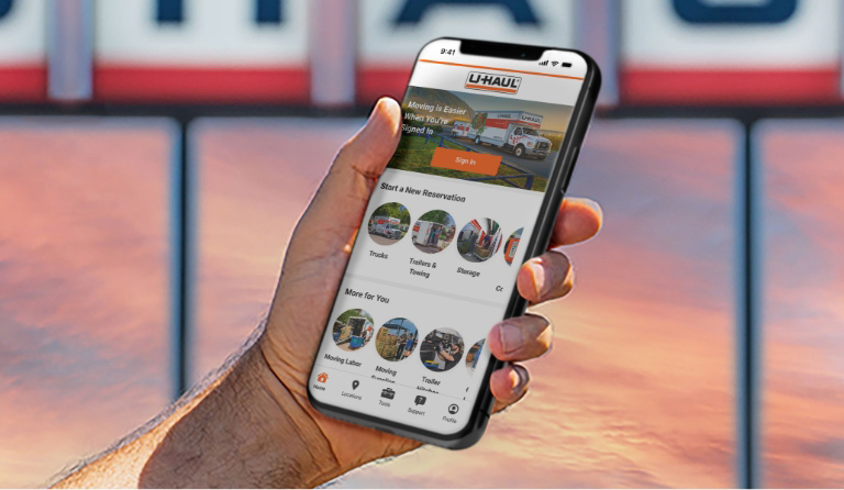 A hand holding the U-Haul App on a smartphone