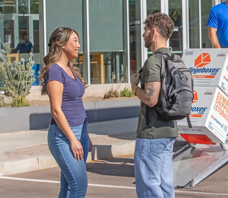 A team of moving helpers loading college boxes into a U-Haul truck