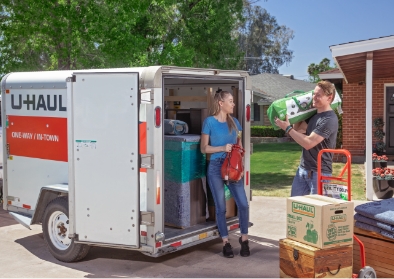 A couple moving household into a UHaul trailer