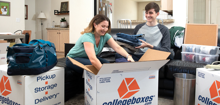 A couple loading items into Collegeboxes in their apartment