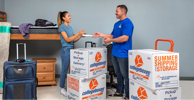 A moving helper loading college boxes into a girl's dorm room