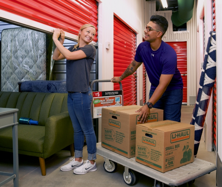 Couple moving items into a U-Haul storage facility