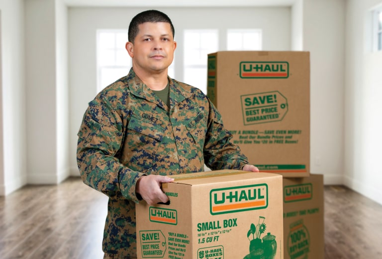 Military service member holding a U-Haul moving box