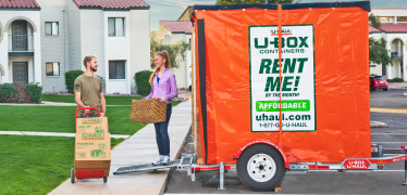 Military couple loading a U-Box moving container in their driveway