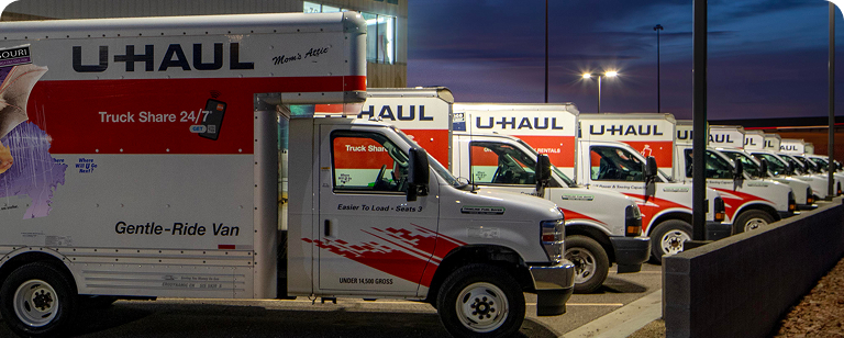 U-Haul Moving Trucks parked outside a U-Haul Rental Facility at night