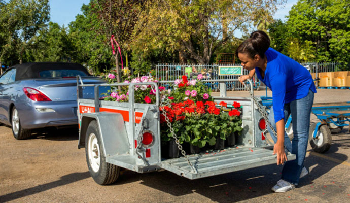 Woman loading a utility trailer with flowers
