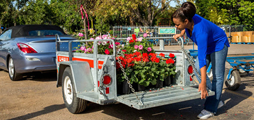A U-Haul Utility trailer loaded with flowering plants