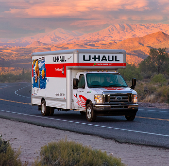 A U-Haul truck driving on a scenic road