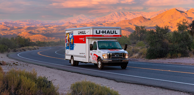 A U-Haul truck driving on a scenic road