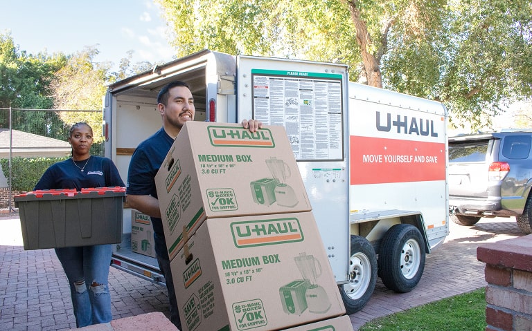 Moving helpers unloading a U-Haul moving truck