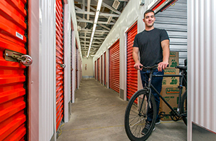Man with bike and boxes in storage unit