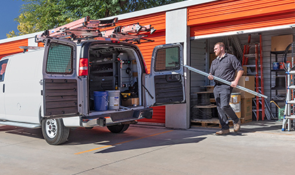 Business owner loading items from a self storage container into a company vehicle