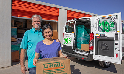 Home owners loading boxes into a rental van from a storage unit