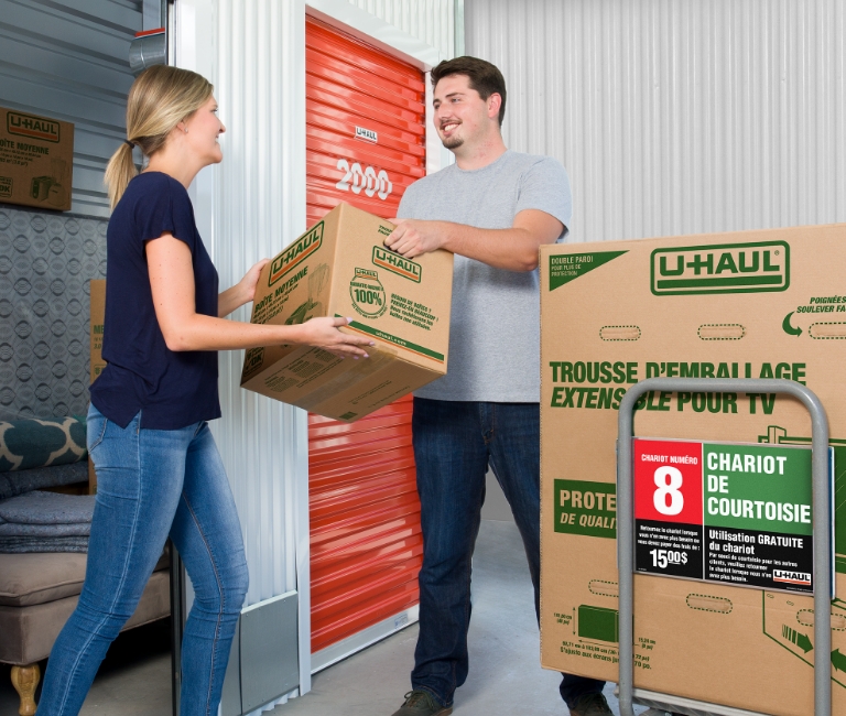 Un couple charge des boîtes dans un conteneur de libre-entreposage