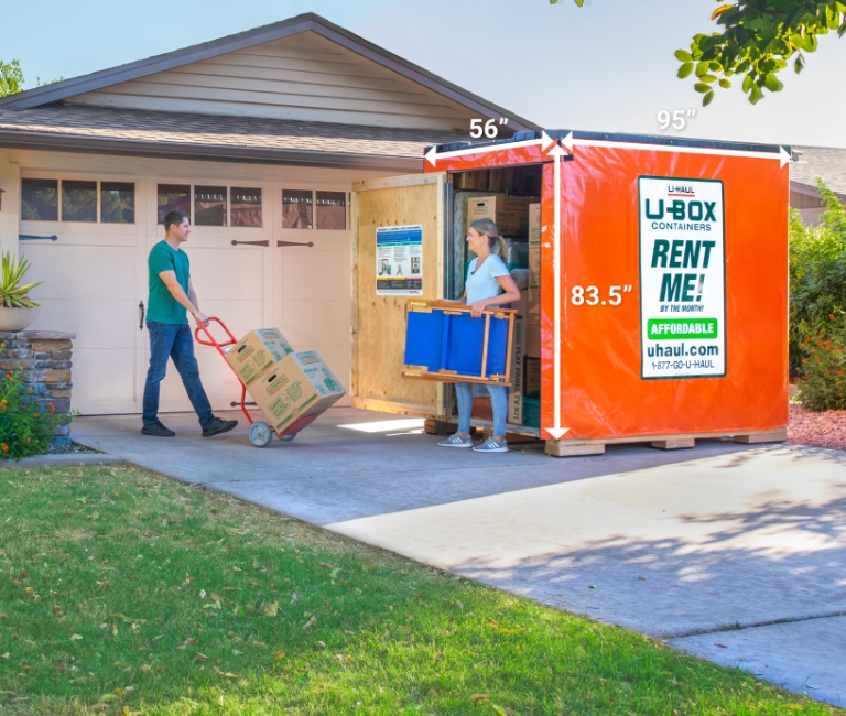 Couple loading a UBox in their driveway