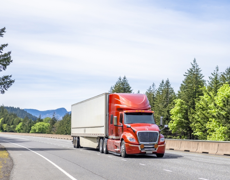 A commercial tractor-trailer traveling along a highway