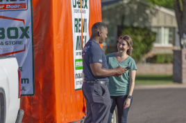 A couple standing beside a U-Haul Portabe Storage Container