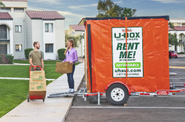 A couple standing beside a U-Haul Portabe Storage Container