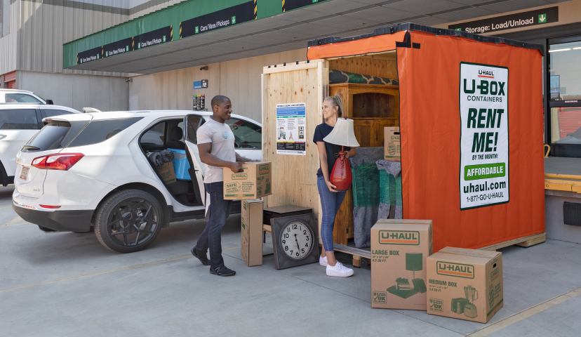 A couple loading a U-Box portable storage container at a U-Haul storage facility