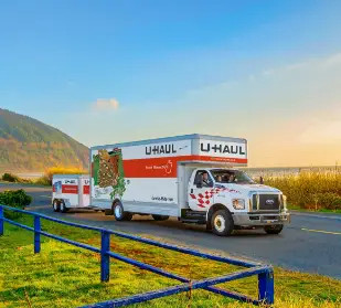 U-Haul moving truck driving on a coastal road.